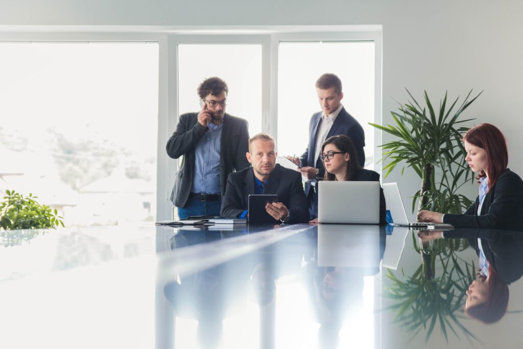 A group of professionals discussing business matters in a conference room, assured by 24/7 support