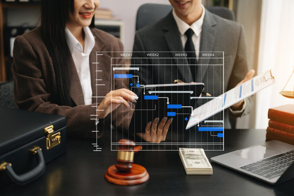 A businessman and woman in business suits looking at a laptop screen