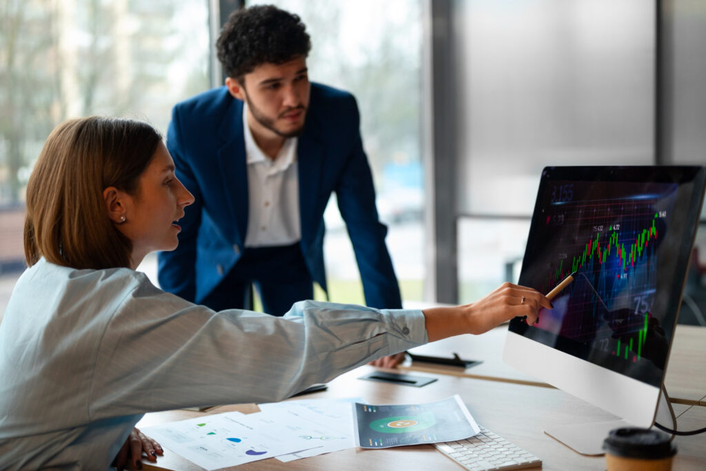 A man and woman focused on a computer screen, engrossed in what they see.