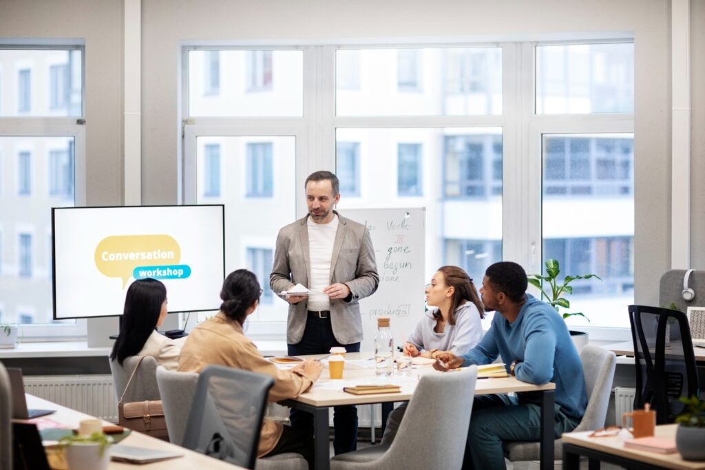 A man presenting to a group of people, engaging them with his speech and captivating body language