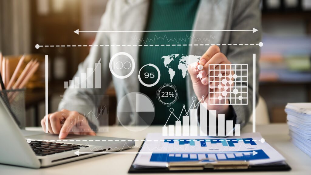 A businesswoman sitting at a desk, using a laptop to create graphs and charts on the screen. This illustrates cost-effective data analysis and management.