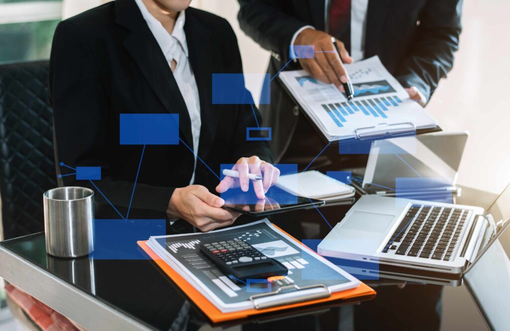 A group of professionals collaborating on laptops and tablets in a modern office setting