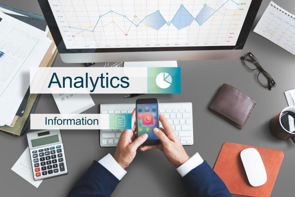 A laptop and phone on a desk displaying analytics information.