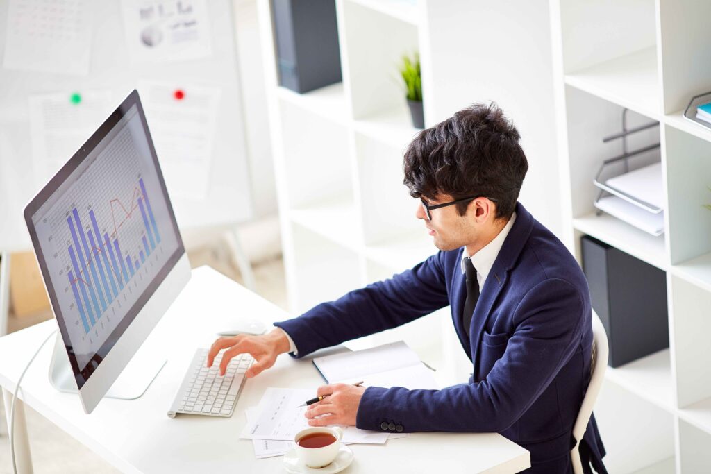 A professional man in a suit focused on his work, typing on a computer keyboard diligently