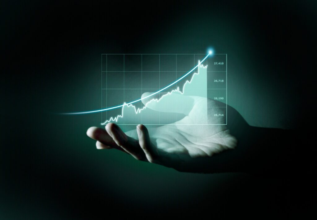 A businessman's hand holds a graph chart on a dark background, symbolizing financial analysis and growth.