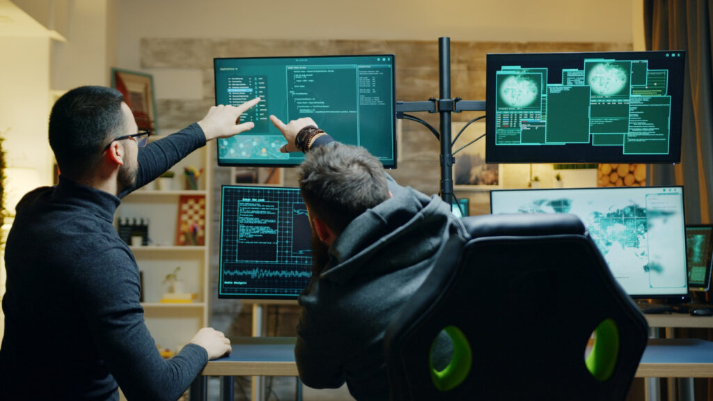 Two men analyzing data on a computer screen