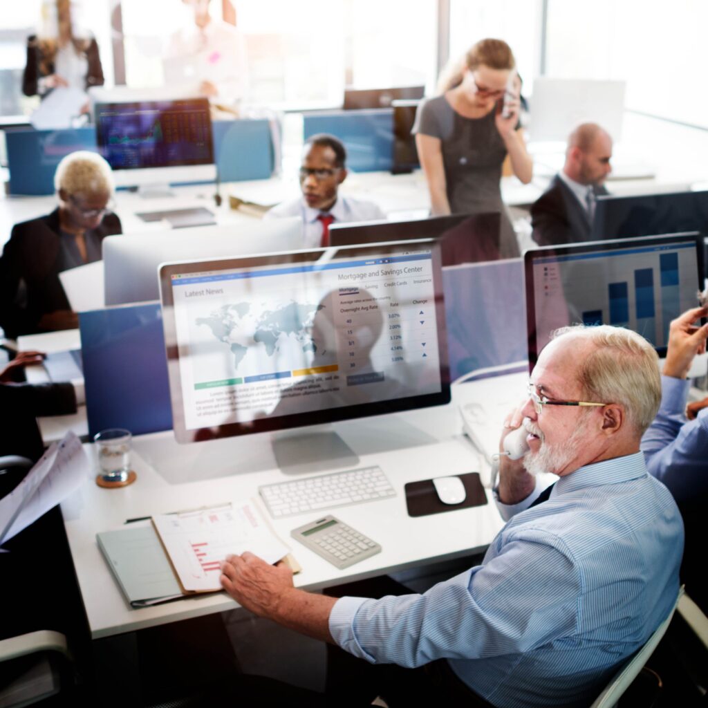 A diverse group of professionals working on computers in a modern office setting