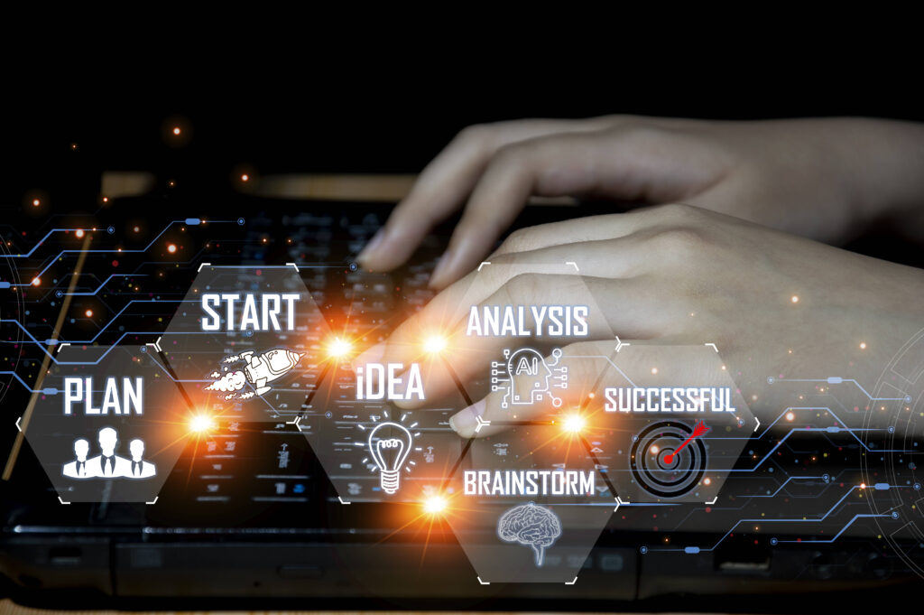 A businesswoman sitting at a desk, using a laptop to work on a business concept, strategically incorporating Strategic IT planning for long-term success.