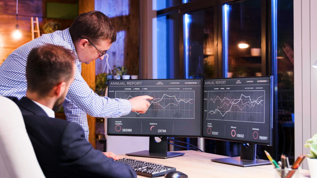 Two men collaborating on a computer screen engaged in a productive work session, implementing Threat Detection and Response Strategies