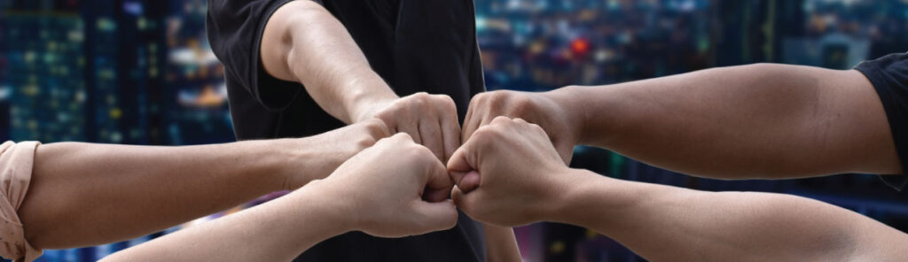 Pair of individuals holding hands with urban view behind them.