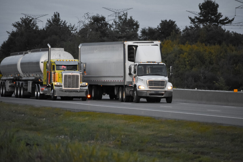 Two semi trucks driving on a highway.