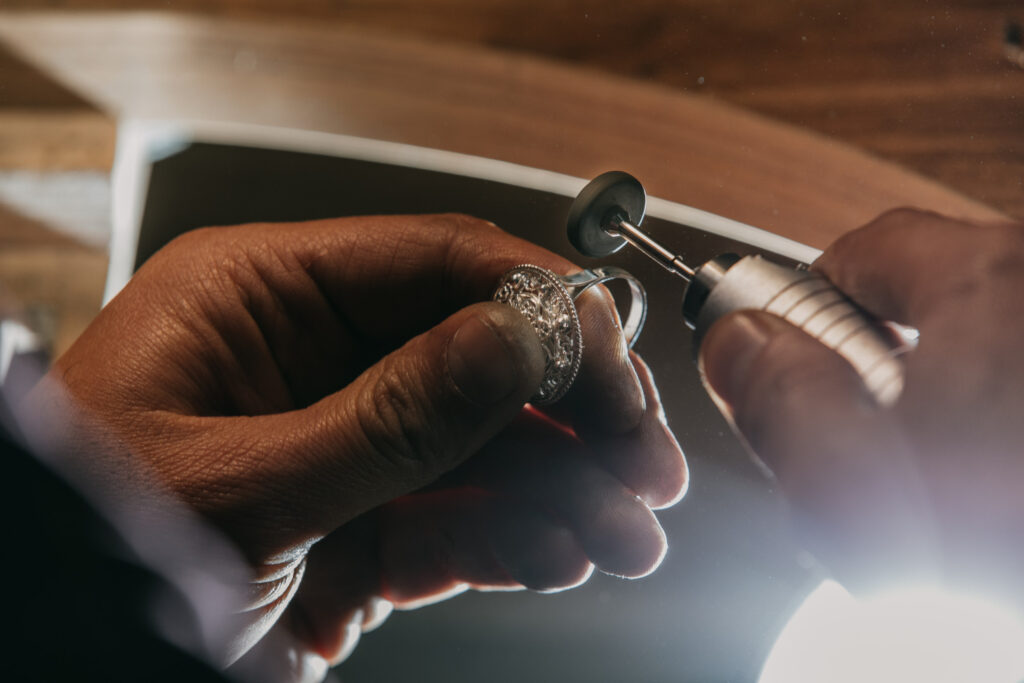 A person carefully cutting a diamond with a precision tool.