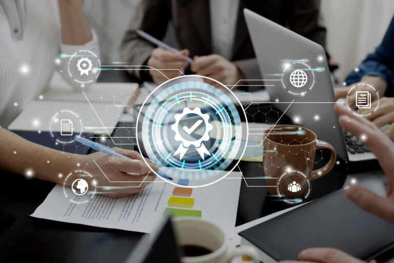 People working at a desk with documents and laptops, overlaid with digital icons symbolizing managed services, including a checkmark badge, a globe, and network connections