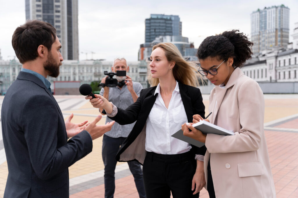 A man and woman engaged in conversation with a reporter, discussing a topic of interest