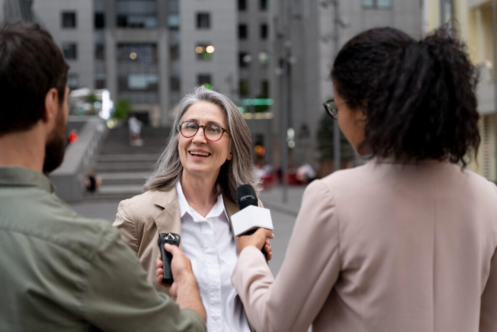 A woman conversing with a reporter in the city, discussing an undisclosed topic.